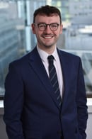Portrait image of Harry Carling in a dark blue suit and tie
