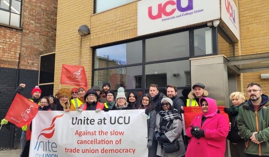 A group of about 25 Unite members picketing their workplace at UCU on Carlow Street in London. Some are holding red Unite flags and a group is holding a large banner reading: Unite at UCU against the slow cancellation of trade union democracy.